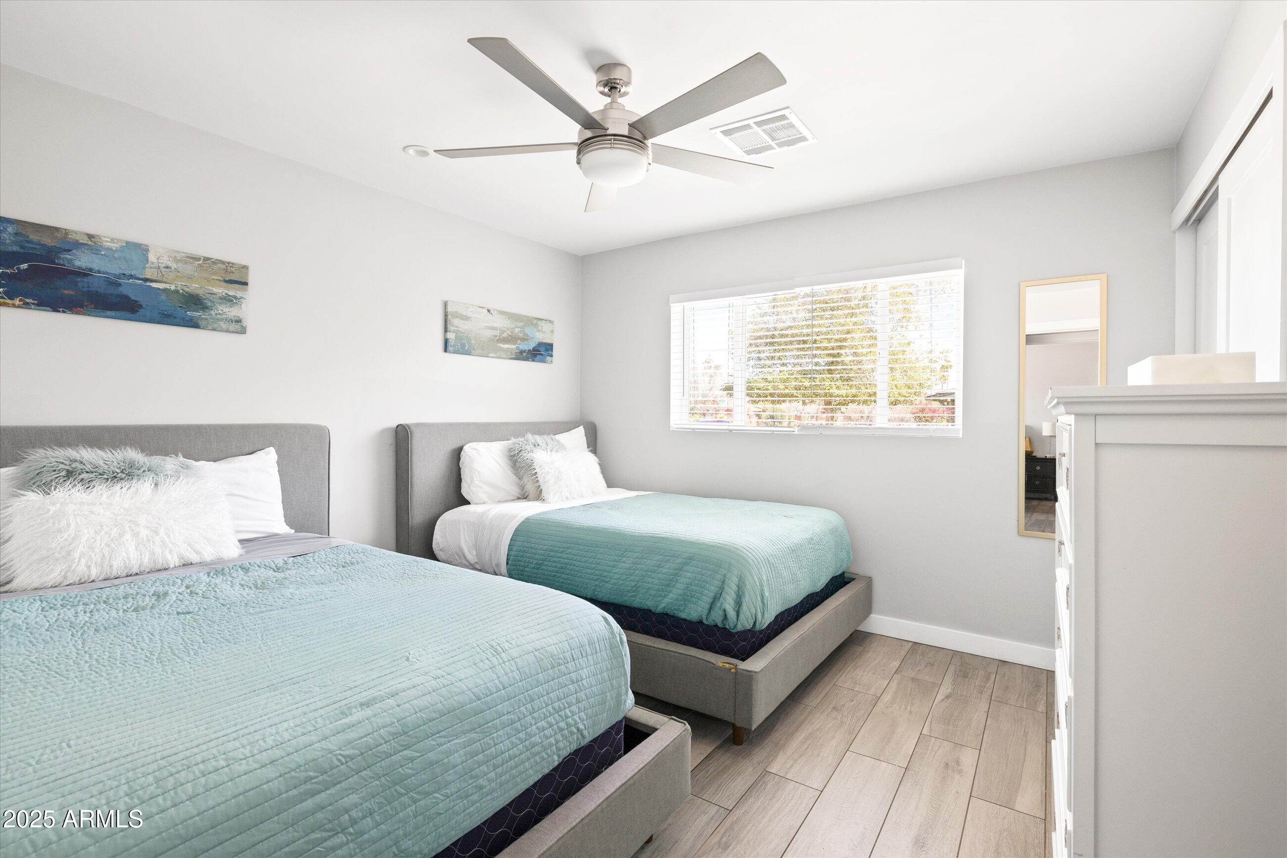 8201 East Piccadilly Road Scottsdale, AZ 85251 - Photo 17 of 26 a bedroom with two beds and a chandelier
