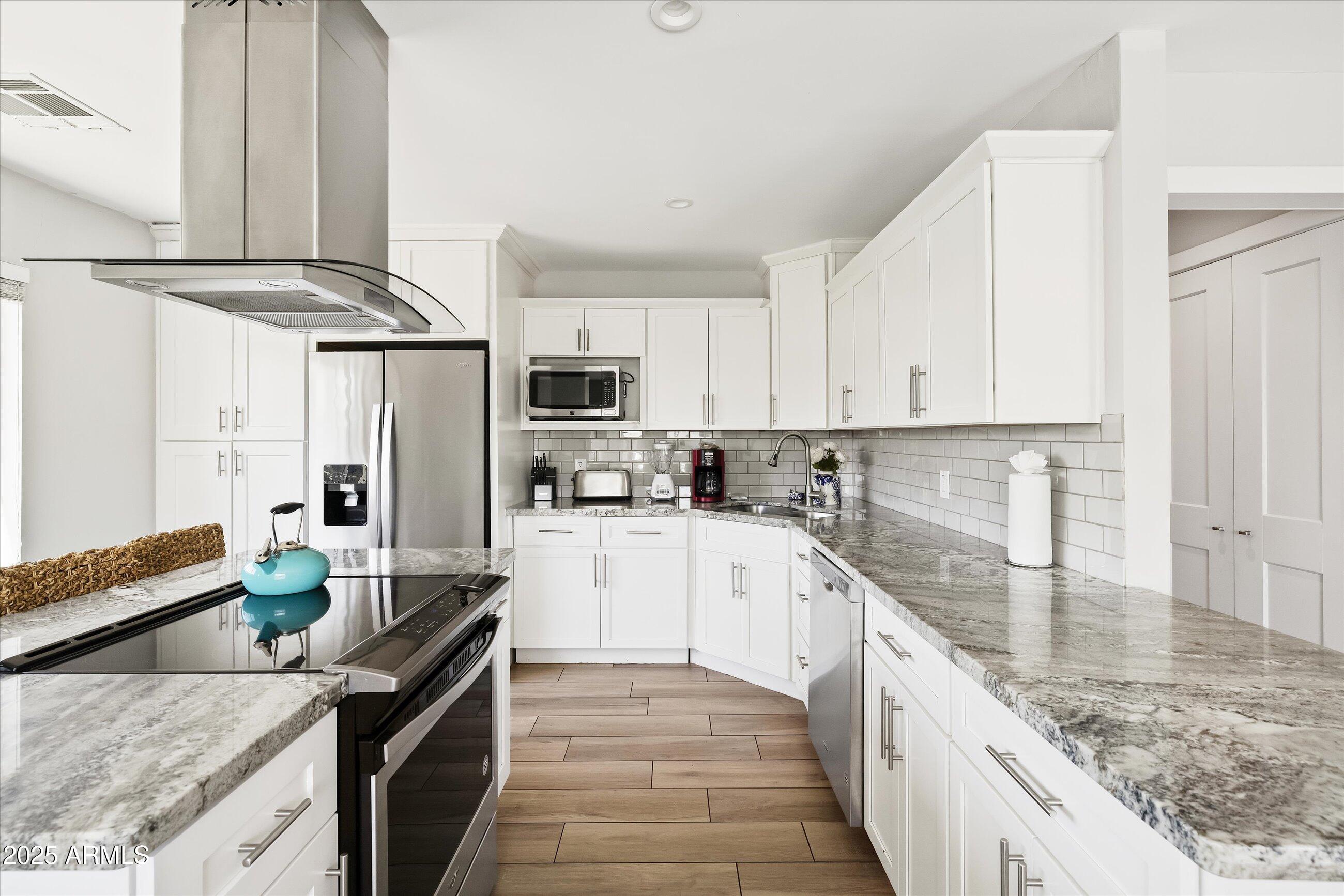 8201 East Piccadilly Road Scottsdale, AZ 85251 - Photo 3 of 26 a kitchen with stainless steel appliances granite countertop a sink stove and refrigerator