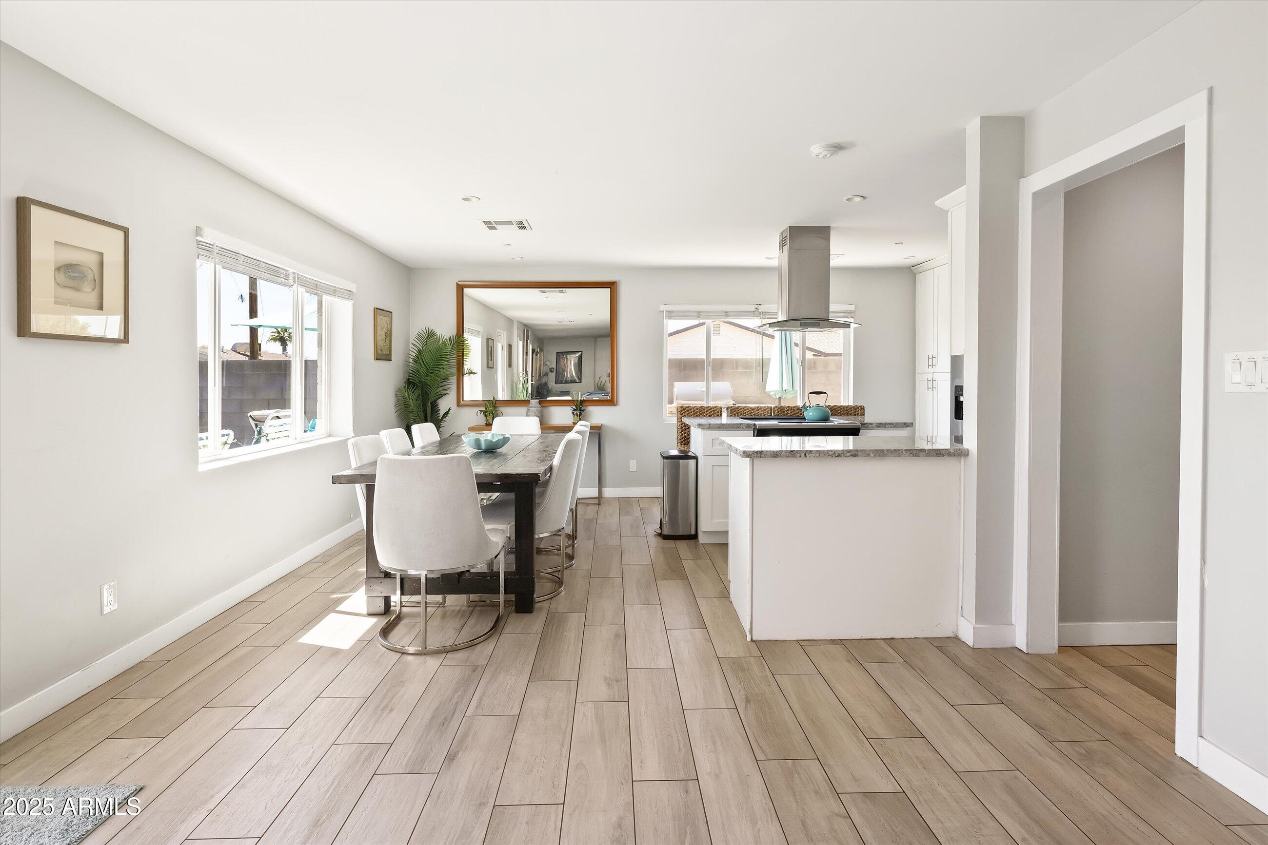 8201 East Piccadilly Road Scottsdale, AZ 85251 - Photo 8 of 26 a view of a dining room with furniture and wooden floor