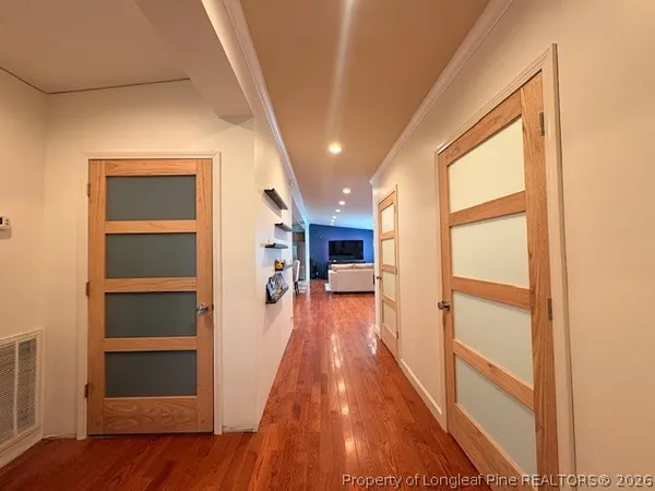 a hallway view with wooden floor and staircase
