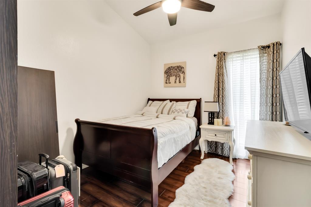 4434 Middlebrook Road, Unit 4 Orlando, FL 32811 - Photo 20 of 31 a bedroom with a bed and a chandelier