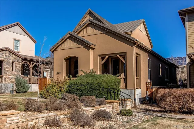 a view of a white house with large windows next to a road