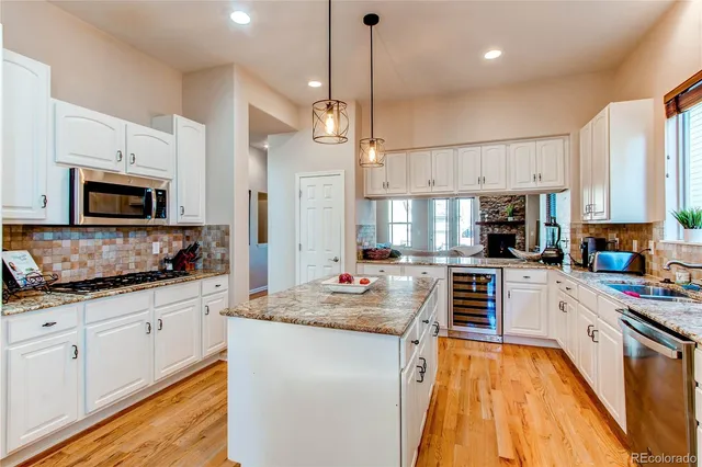 a kitchen with stainless steel appliances granite countertop a stove top oven a sink a microwave and cabinets