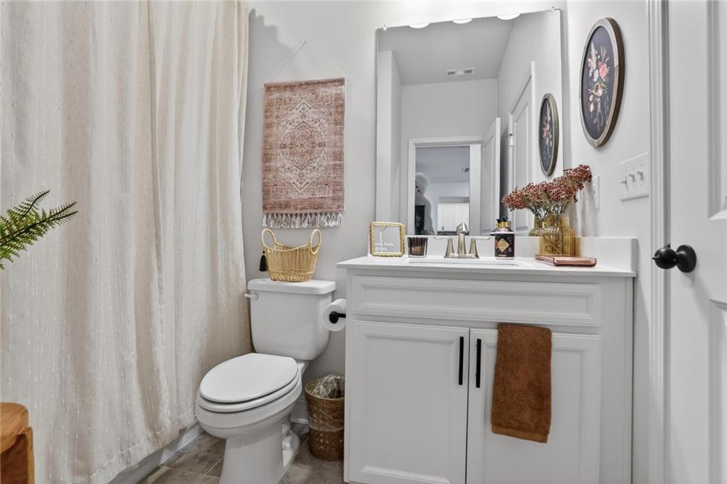 454 Carmichael Circle Canton, GA 30115 - Photo 16 of 30 a bathroom with a toilet a sink and a mirror