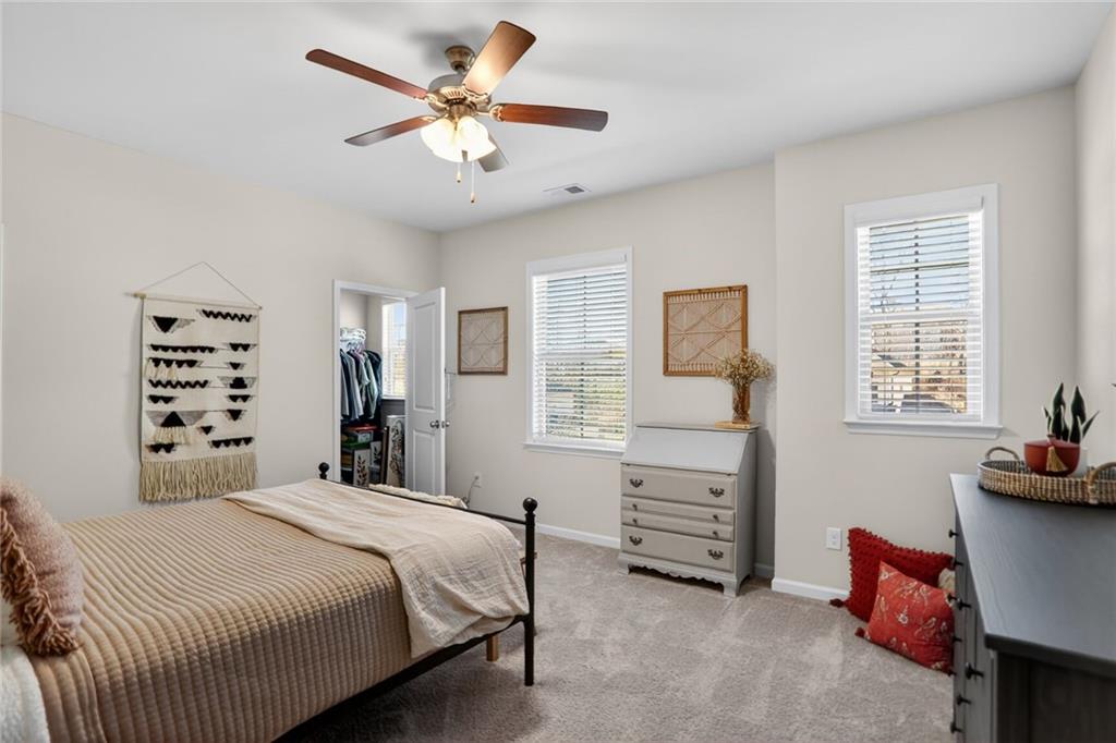 454 Carmichael Circle Canton, GA 30115 - Photo 27 of 30 a bedroom with a bed a chandelier and a window