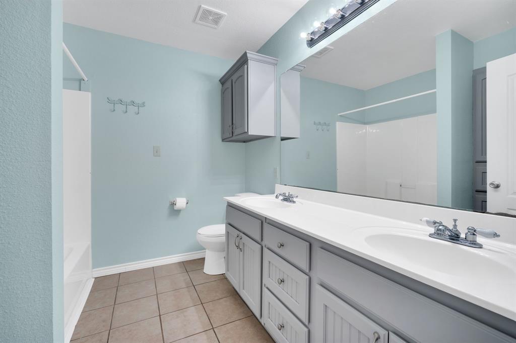130 Eubanks Road Maypearl, TX 76064 - Photo 8 of 39 a spacious bathroom with a double vanity sink a mirror and a toilet
