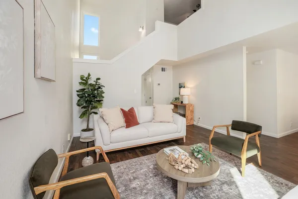 a living room with furniture a rug and a lamp
