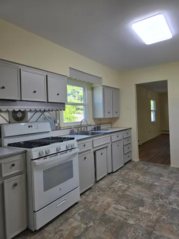 a kitchen with granite countertop white cabinets and white appliances