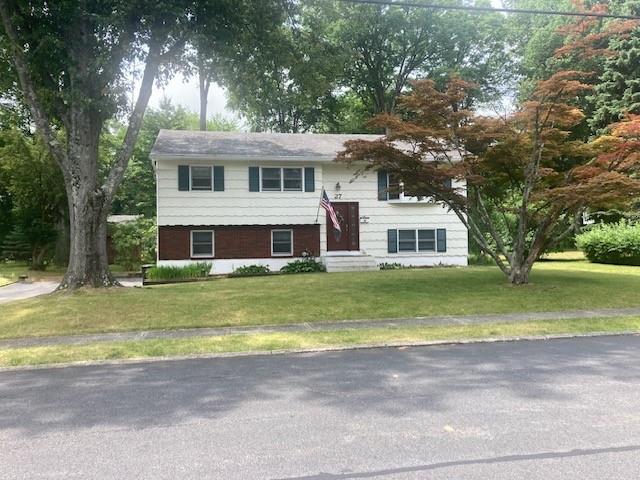 a front view of houses with yard and green space