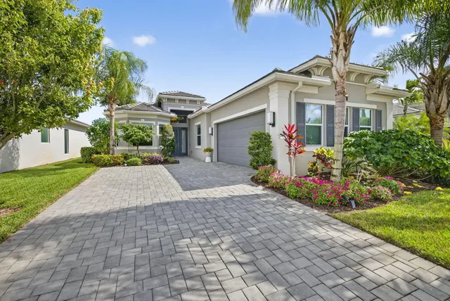 a front view of a house with a yard and potted plants