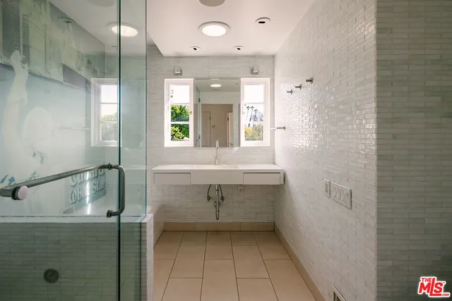 a bathroom with a sink shower and a mirror