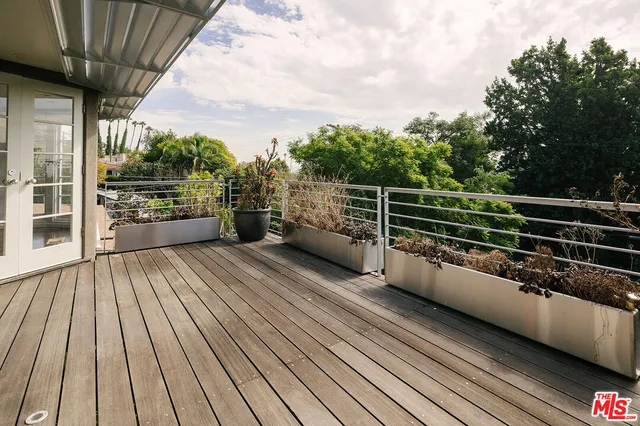 a view of a balcony with wooden floor and iron stairs