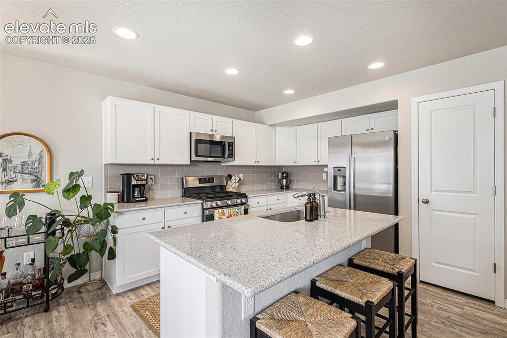 2940 Magic Carpet Loop Colorado Springs, CO 80916 - Photo 8 of 21 a kitchen with white cabinets and appliances