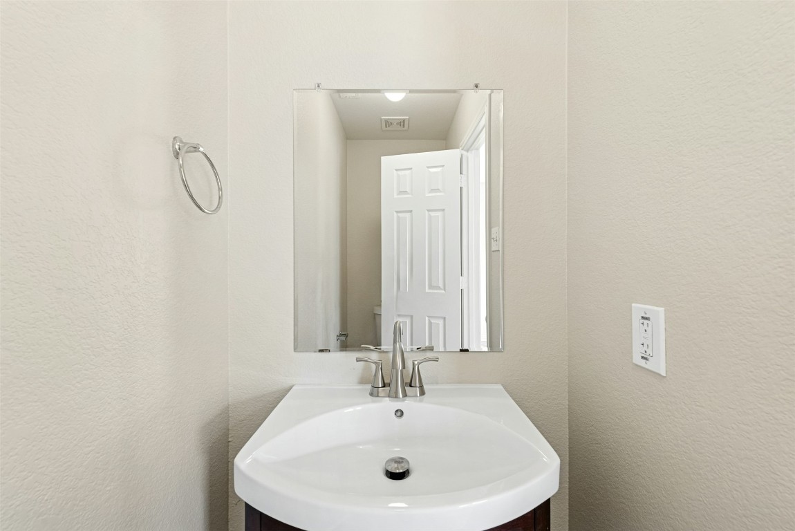 17913 Honey Locust Lane Elgin, TX 78621 - Photo 14 of 31 a bathroom with a sink and a mirror