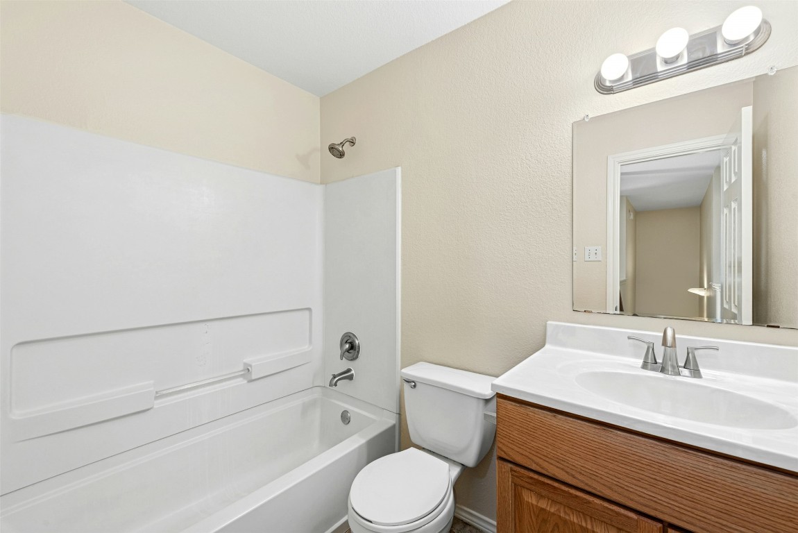 17913 Honey Locust Lane Elgin, TX 78621 - Photo 26 of 31 a bathroom with a sink toilet vanity and shower