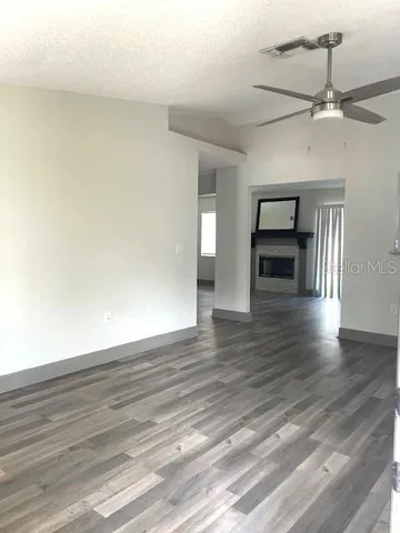 a view of a kitchen with wooden floor electronic appliances and stairs