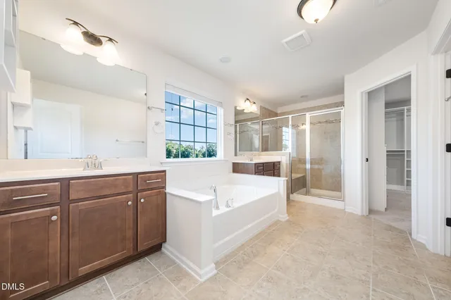 a large white kitchen with a large window and refrigerator