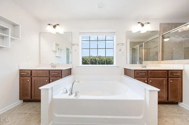 a spacious bathroom with a tub sink and mirror