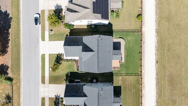an aerial view of residential houses with outdoor space and parking