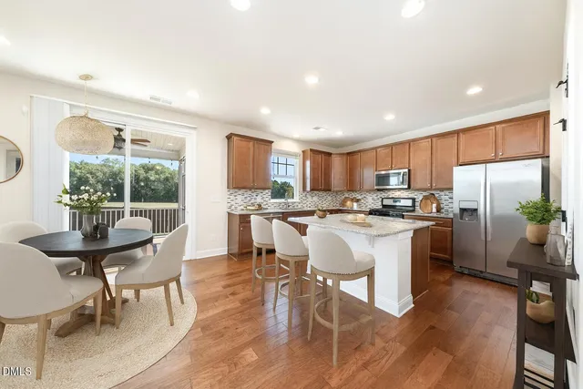 a kitchen with refrigerator a sink and chairs