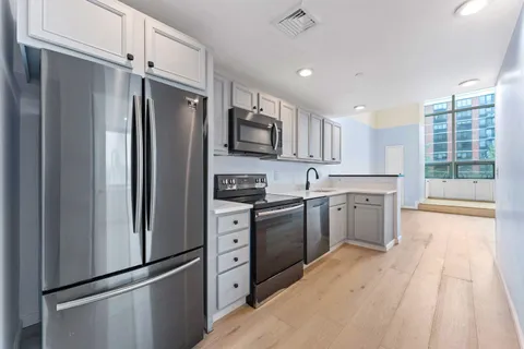 a kitchen with stainless steel appliances granite countertop a refrigerator sink and cabinets