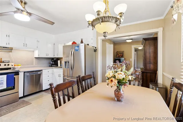 a kitchen with stainless steel appliances granite countertop a dining table chairs and granite counter tops