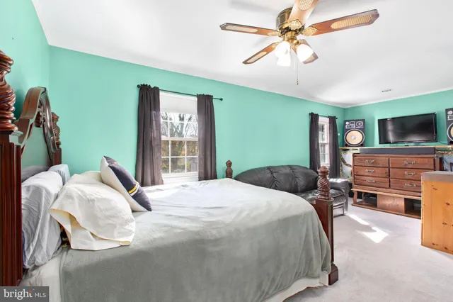 a bedroom with a bed dresser and a window