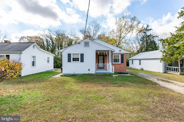 a view of a house with a yard and large tree
