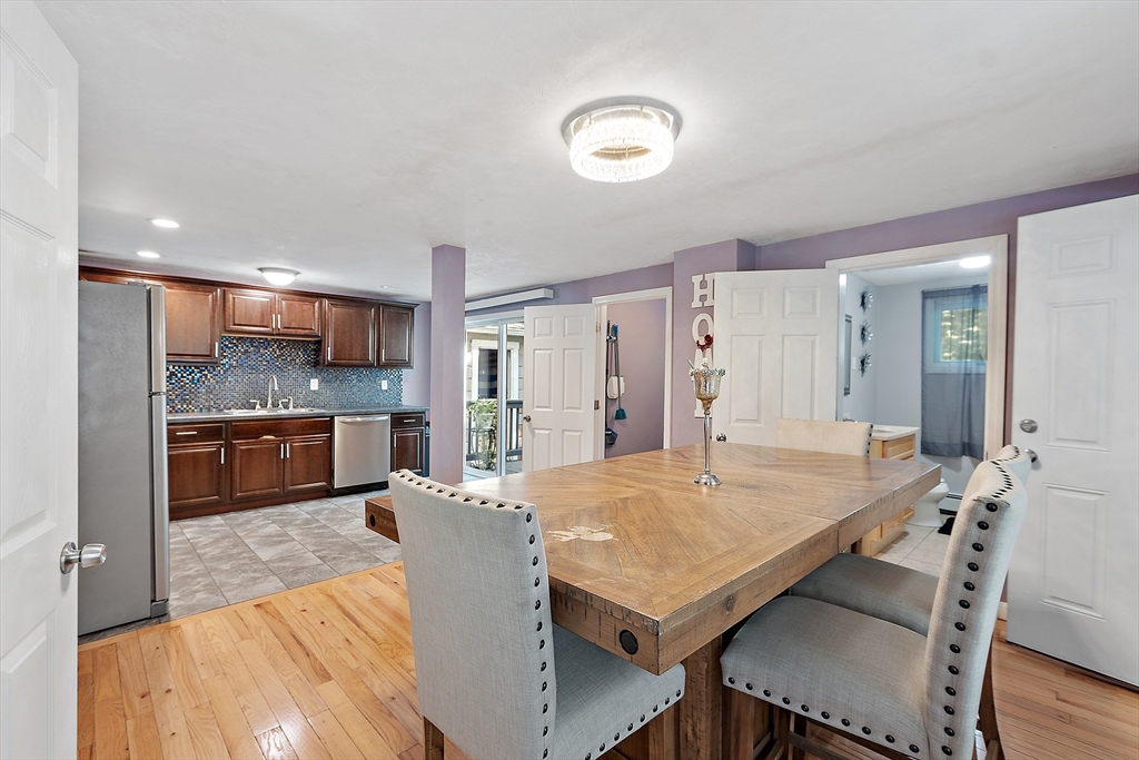 506 Pleasant Street Gardner, MA 01440 - Photo 22 of 41 a kitchen with kitchen island a dining table chairs and white cabinets