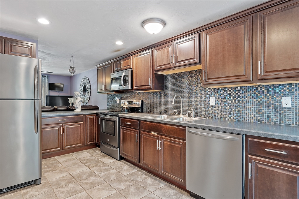 506 Pleasant Street Gardner, MA 01440 - Photo 24 of 41 a kitchen with stainless steel appliances granite countertop a refrigerator sink and cabinets