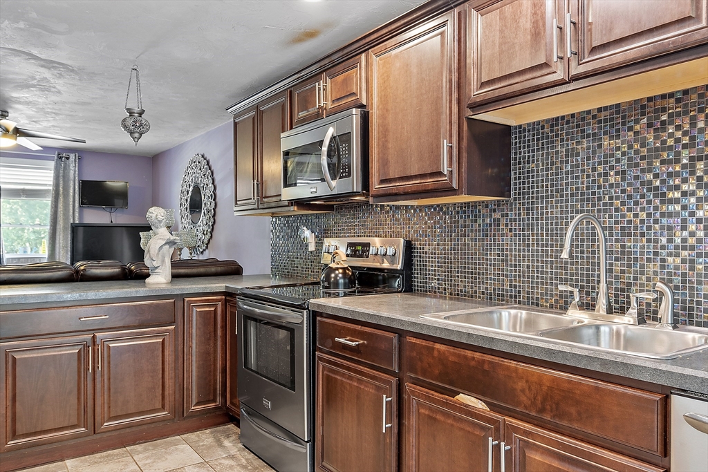 506 Pleasant Street Gardner, MA 01440 - Photo 26 of 41 a kitchen with stainless steel appliances granite countertop a sink a stove and cabinets