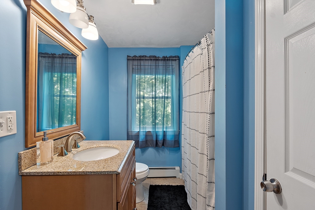 506 Pleasant Street Gardner, MA 01440 - Photo 29 of 41 a en suite bathroom with a granite countertop sink a mirror and a shower