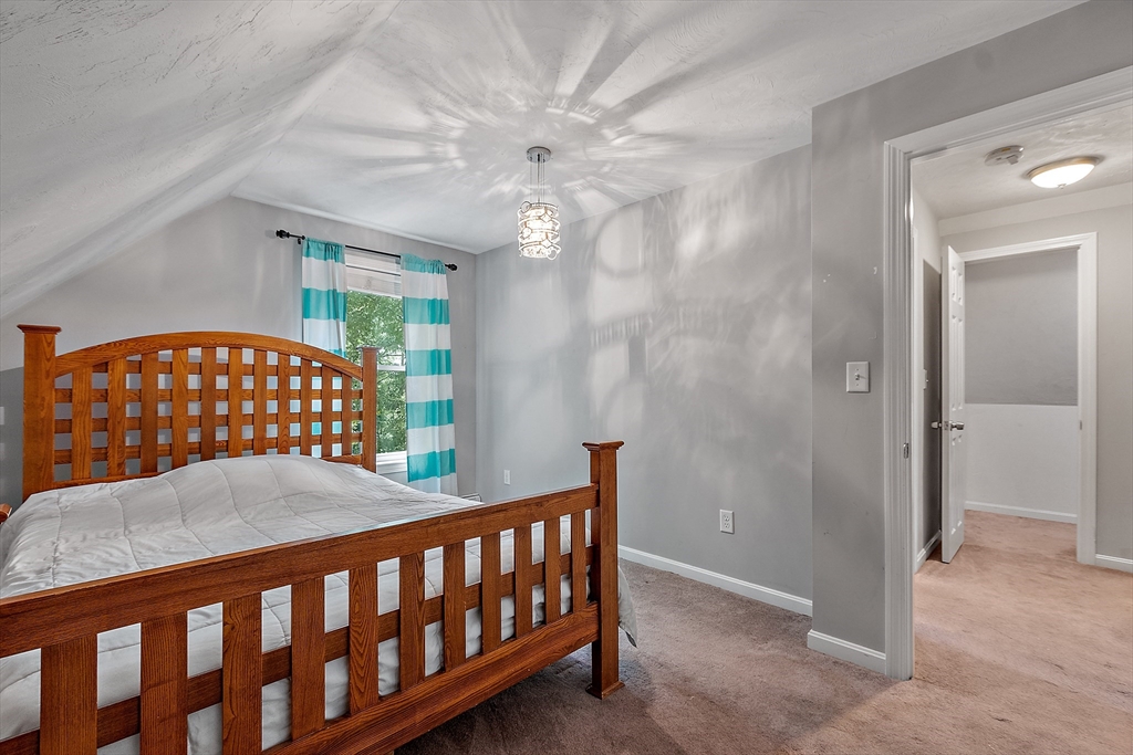 506 Pleasant Street Gardner, MA 01440 - Photo 31 of 41 a bedroom with a bed and a chandelier
