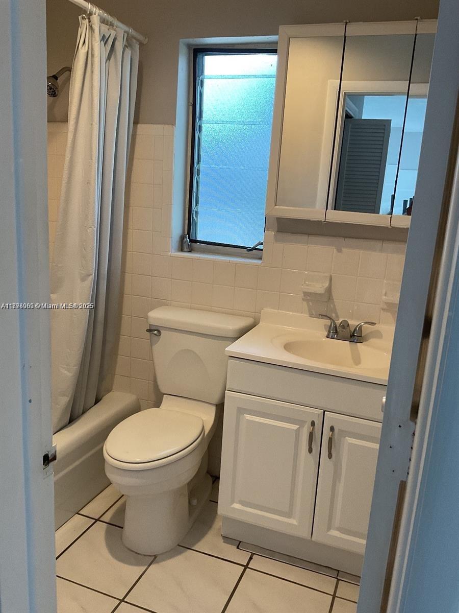 90 Isle Of Venice Drive, Unit 8 Fort Lauderdale, FL 33301 - Photo 3 of 7 a bathroom with a sink a toilet a mirror and shower