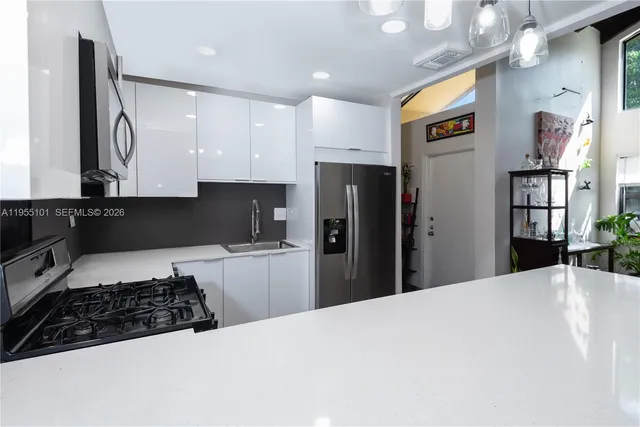 a kitchen with stainless steel appliances granite countertop a refrigerator and a stove top oven