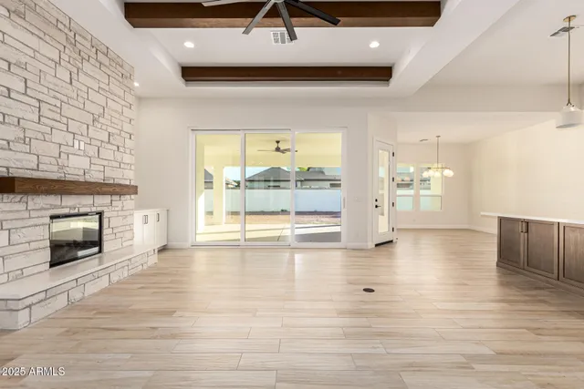 an open kitchen with a refrigerator a sink and a stove top oven with wooden floor