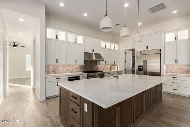 an empty room with wooden floor ceiling fan and windows