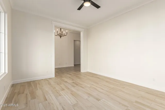 an empty room with a window and a ceiling fan