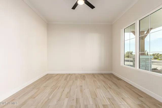 an empty room with chandelier fan