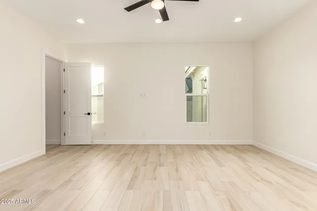an empty room with fan and windows