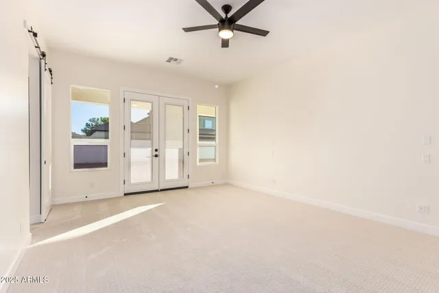 an empty room with a window and a ceiling fan