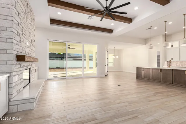 a view of an empty room with wooden floor and a fireplace