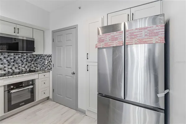 a kitchen with stainless steel appliances granite countertop a refrigerator and a stove top oven