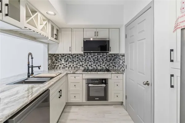 a kitchen with granite countertop a sink stainless steel appliances and cabinets