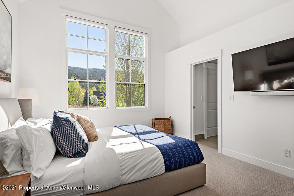 334 Sopris Circle Basalt, CO 81621 - Photo 11 of 34 a bedroom with a bed a flat screen tv and windows