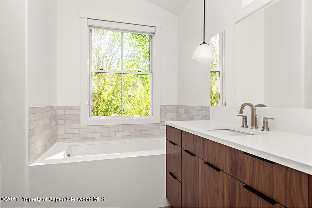 334 Sopris Circle Basalt, CO 81621 - Photo 13 of 34 a bathroom with a granite countertop sink a bathtub and a window