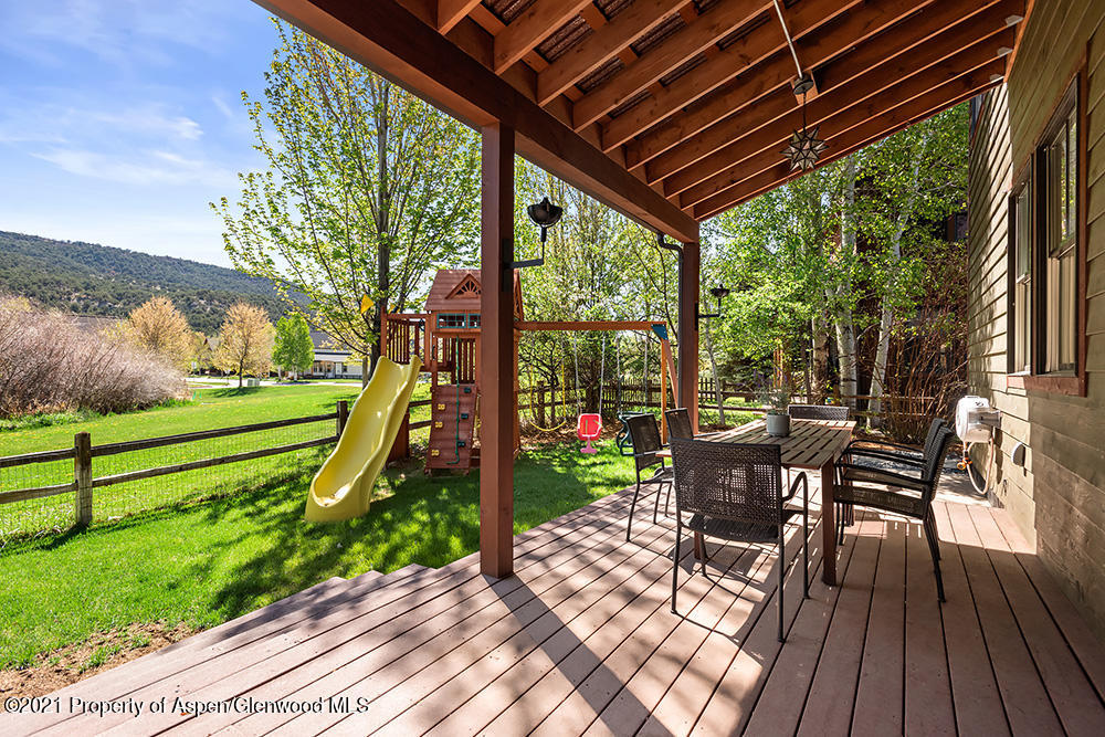 334 Sopris Circle Basalt, CO 81621 - Photo 27 of 34 a view of a patio with table and chairs potted plants with wooden floor and fence