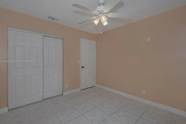 an empty room with a ceiling fan and a shower