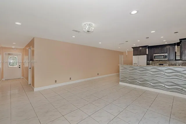 an empty room with kitchen appliances and cabinets