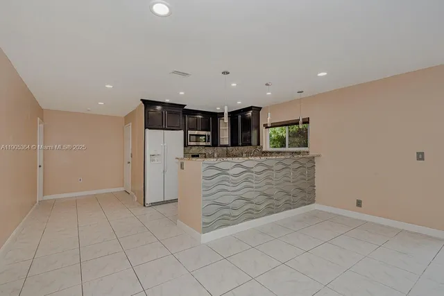 an empty room with kitchen view
